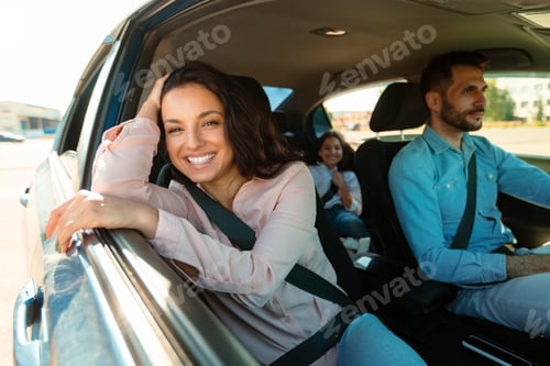 Preview: Happy family in car, woman smiling to camera sitting on passenger seat, enjoying trip by their new