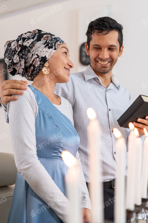Preview: Jewish couple celebrating Hanukkah, lighting candles and embracing love.