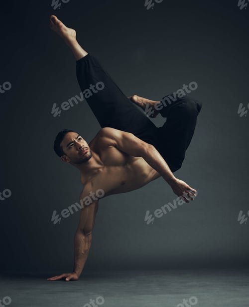 Preview: Full length shot of a handsome young man performing a martial arts kick in the studio