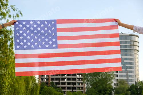 Preview: Two human hands holding USA national flag. Celebration of United States independence day concept