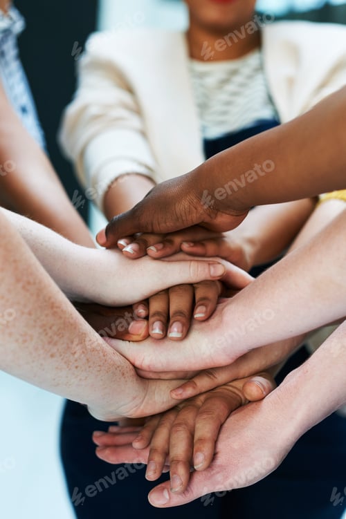 Preview: United as a team. Shot of a group of people putting their hands together.