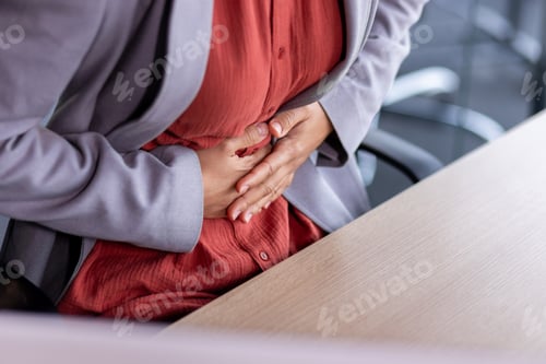 Preview: Stomach ache, sick business woman holding hands on stomach close up, female worker at workplace