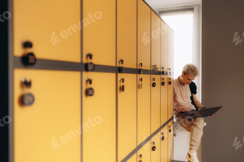 Preview: Student using laptop in locker room at college