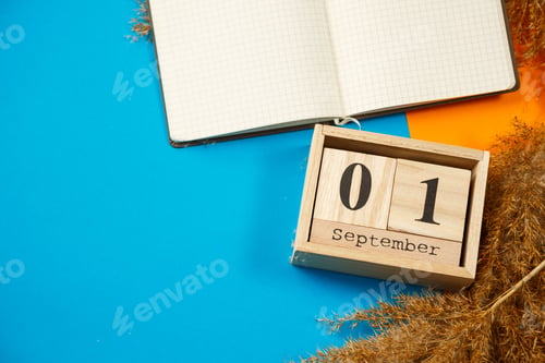 Preview: Calendar of wooden cubes with numbers and months. Notepad with white sheets. The first day of the