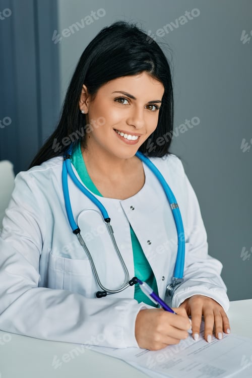 Preview: Doctor occupation. Smiling general practitioner sitting at her workplace wearing medical uniform