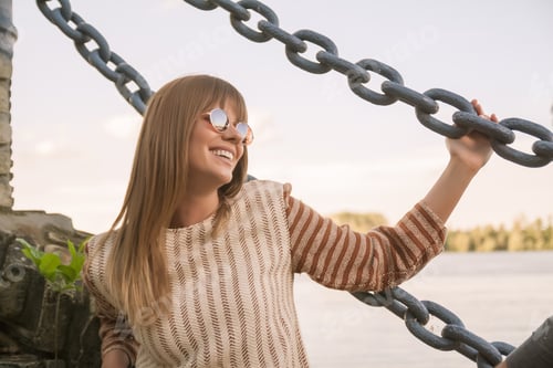 Preview: One Young Adult Caucasian Woman, Smiling, Upper Body Shot, Outdoors Sunny Day, Holding On To Chain