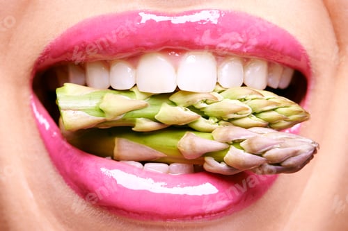 Preview: Vivacious veggies. Cropped shot of a woman biting on a bunch of asparagus.