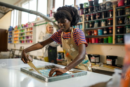 Preview: Multiracial printing shop worker with duck tape preparing printing plate