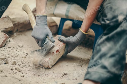 Preview: A young man cleans bricks with an axe.