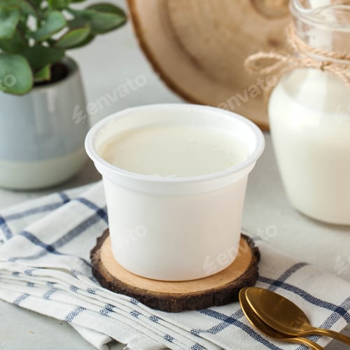 Preview: Creamy natural yogurt in a simple white container, perfect for a healthy and nutritious snack.