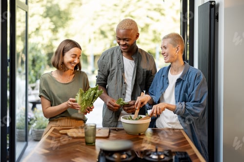 Preview: Friends cooking salad together at home kitchen
