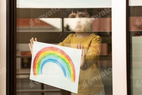 Preview: Little kid holding a drawing of a rainbow through the window