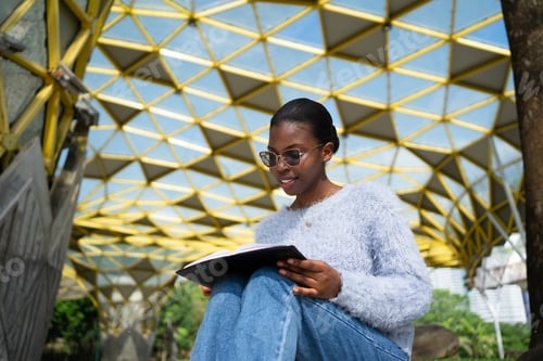 Preview: Smiling student enjoying a book in a modern urban setting