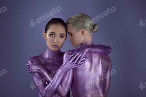 Preview: multiethnic naked girls in ultra violet glitter hugging together, isolated on purple