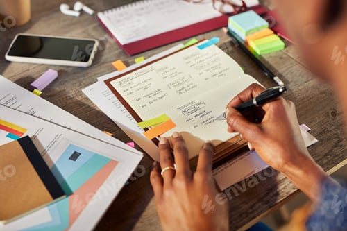 Preview: Back view of african american woman writing weekly schedule on agenda