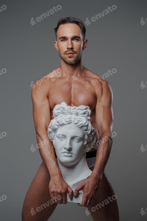 Preview: An attractive male model, dressed only in underwear on a gray backdrop