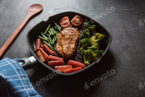 Preview: Chicken steak and vegetables saute in a pan.