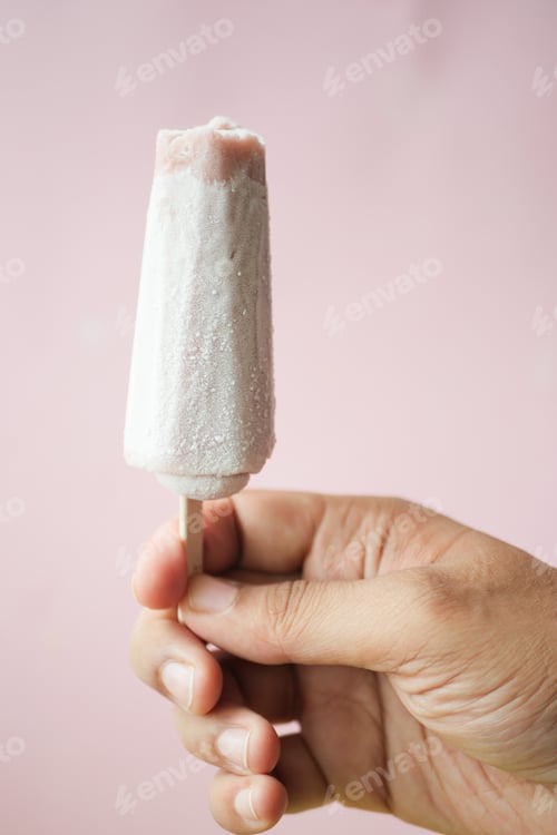 Preview: person hand holding ice cream against blue background with copy space
