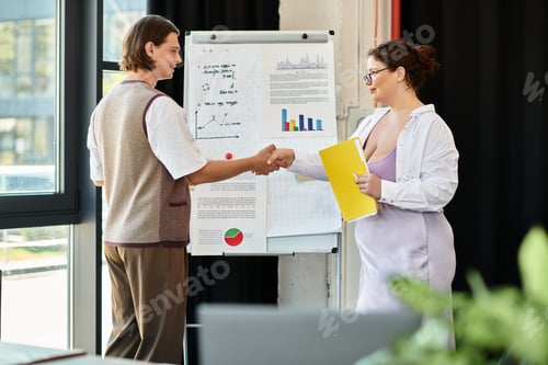 Preview: Young plus size woman and male friend engage in a professional discussion at an office setting