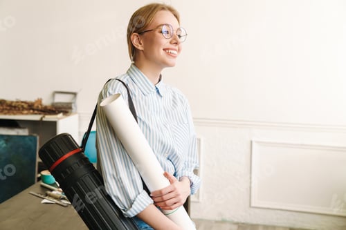 Preview: Photo of woman architect smiling and holding drawing while standing