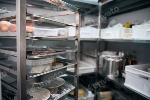 Preview: Focus of dishes on shelves in blurred refrigerator storage in restaurant
