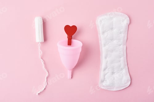 Preview: Sanitary pad, menstrual cup, tampon and red wooden heart on a pink background
