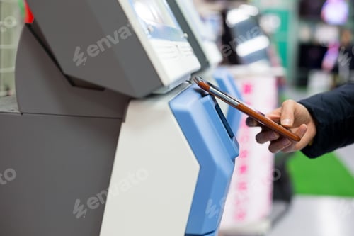 Preview: Woman using smart phone for paying on machine by NFC