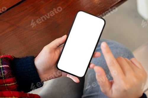Preview: Close-up shot of a woman using her smartphone while sitting at a table indoors.