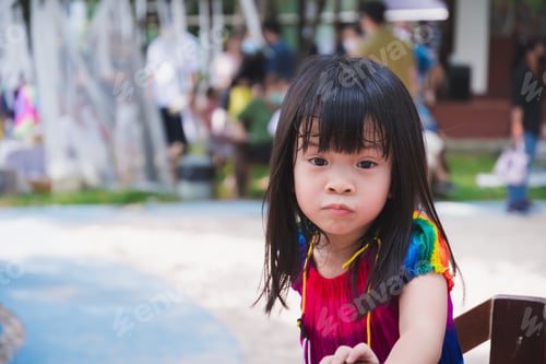 Preview: Closeup cute child shows a funny face. Asian girl are playing in the playground. Summer time.