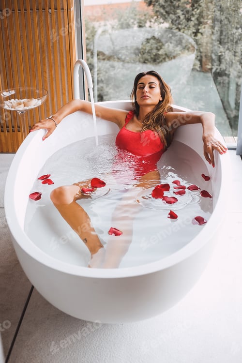 Preview: Woman Relaxing in Bathtub with Red Rose Petals