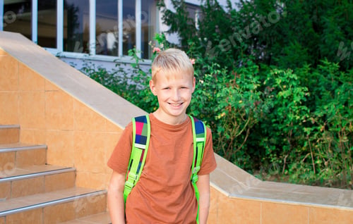 Preview: Back to school. School-age boy with a protective medical mask on her on his face with a school backp