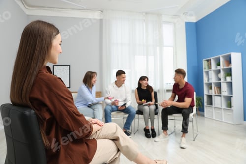 Preview: Group of people having meeting during life coaching class indoors, selective focus