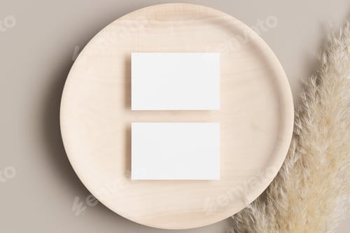 Preview: Two white business cards mockup 85x55mm on a wooden plate with a pampas grass decoration.