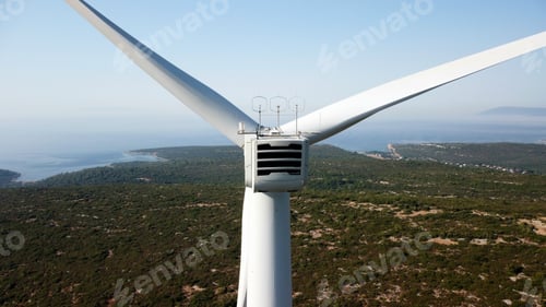 Preview: Closeup of a wind turbine against green mountains