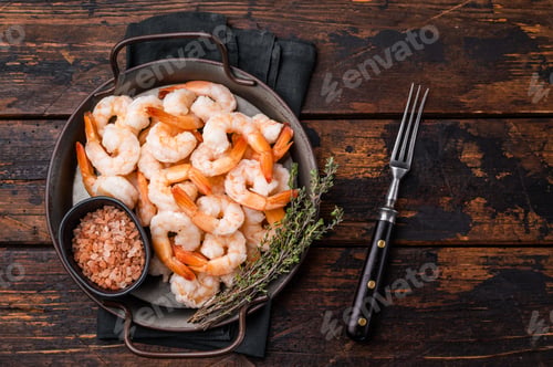 Preview: A plate of shrimp with a black bowl of salt and pepper. The shrimp are arranged