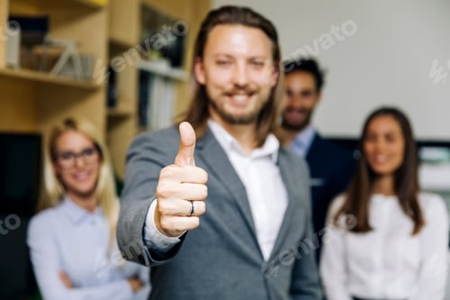Preview: Yuoung businessman with thumb up standing in the office