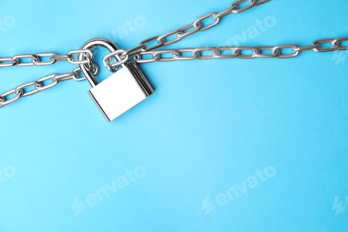 Preview: Steel padlock, chains and space for text on light blue background, top view. Safety concept