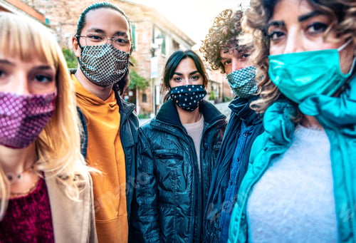 Preview: Community of multiracial people covered by facemasks looking at camera outdoors
