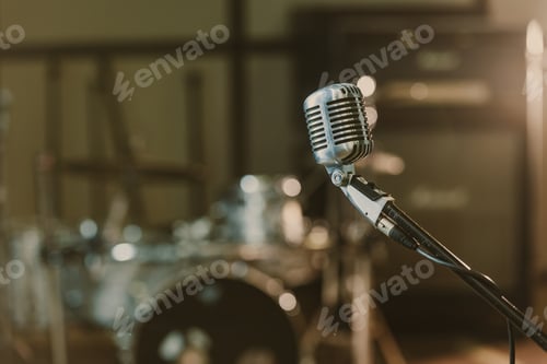 Preview: close-up shot of vintage microphone on stand against blurred drum set