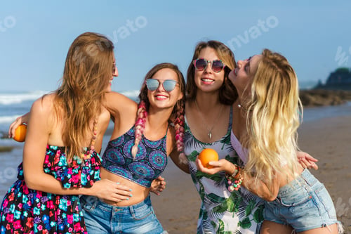 Preview: group of happy young women embracing on beach