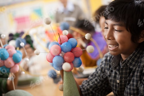 Preview: A group of students around a desk in a science lesson, creating molecular models.