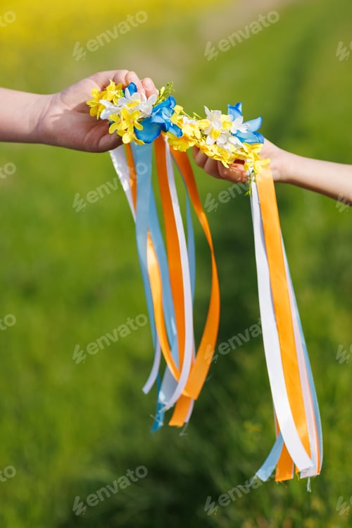 Preview: Close-up on Ukrainian wreath with flowers and ribbons in hands that brings hope for end of war