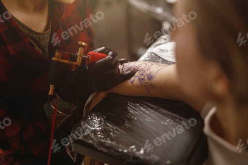 Preview: Close up photo of tattoo master hands in gloves carefully holding tattoo machine