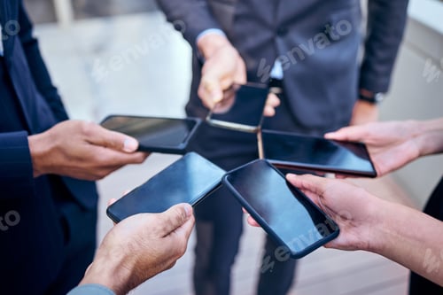 Preview: High angle shot of a group of unrecognisable businesspeople using their cellphones at work