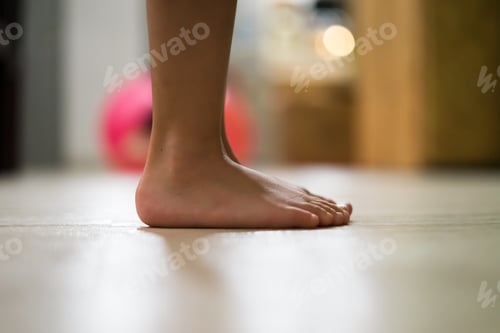 Preview: Children's bare feet. Child's bare feet on the wooden floor