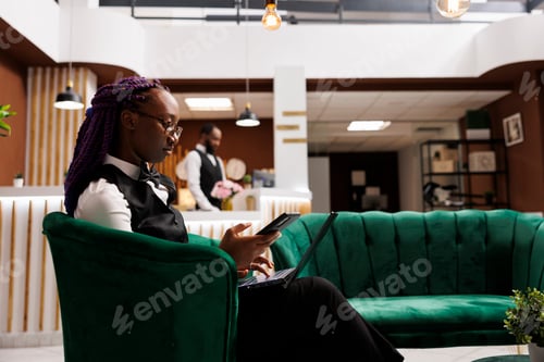 Preview: Hotel manager using phone and laptop