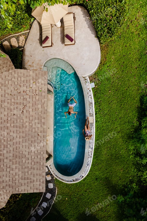 Preview: Drone view from above at a young couple of men and women at a swimming pool during a vacation