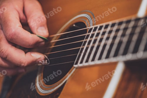 Preview: Closeup of a man's hand playing guitar.