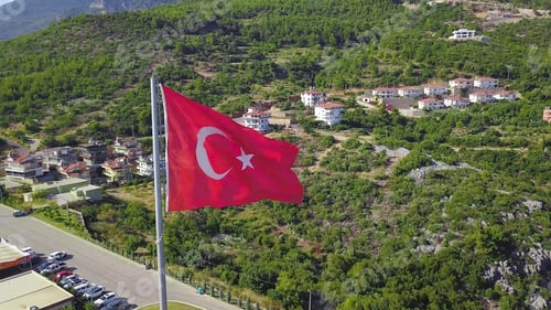 Preview: Top view of Turkish flags on mountain on background of city and sea. Clip. Turkish resort town