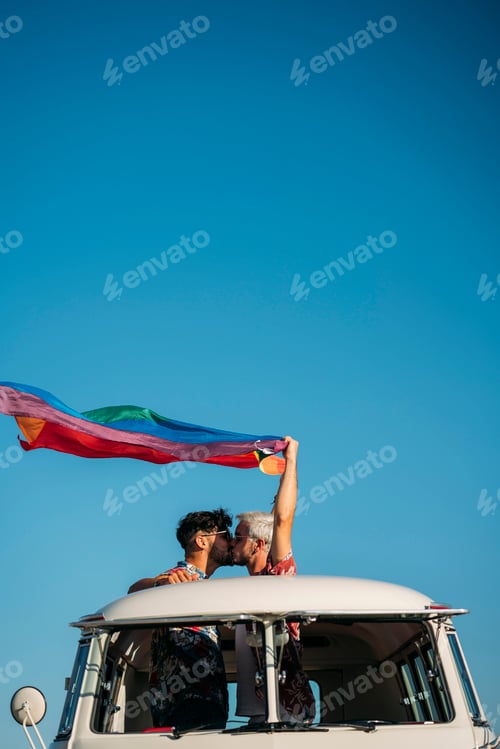 Preview: Kissing gay couple holding LGBT flag